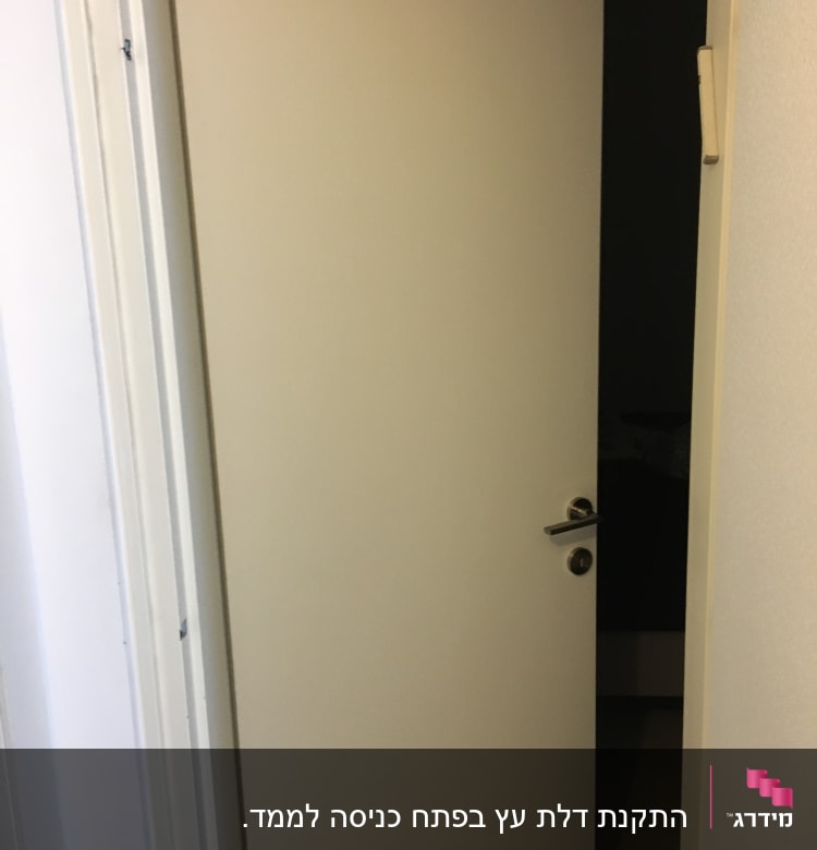 דלת לבנה פתוחה עם ידית מתכת